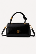 Black handbag with gold accents on a white background