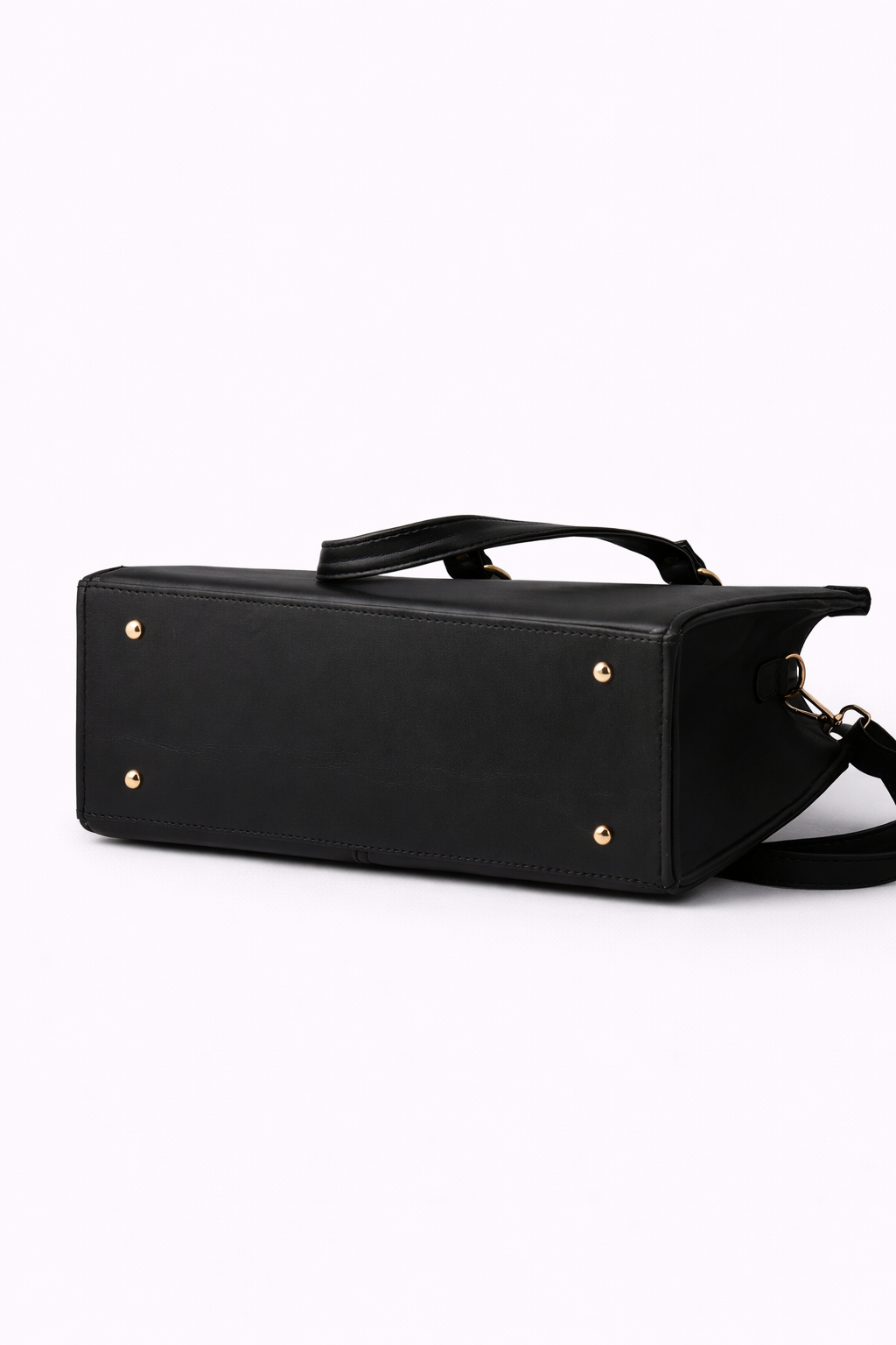 Black handbag with gold studs on a white background